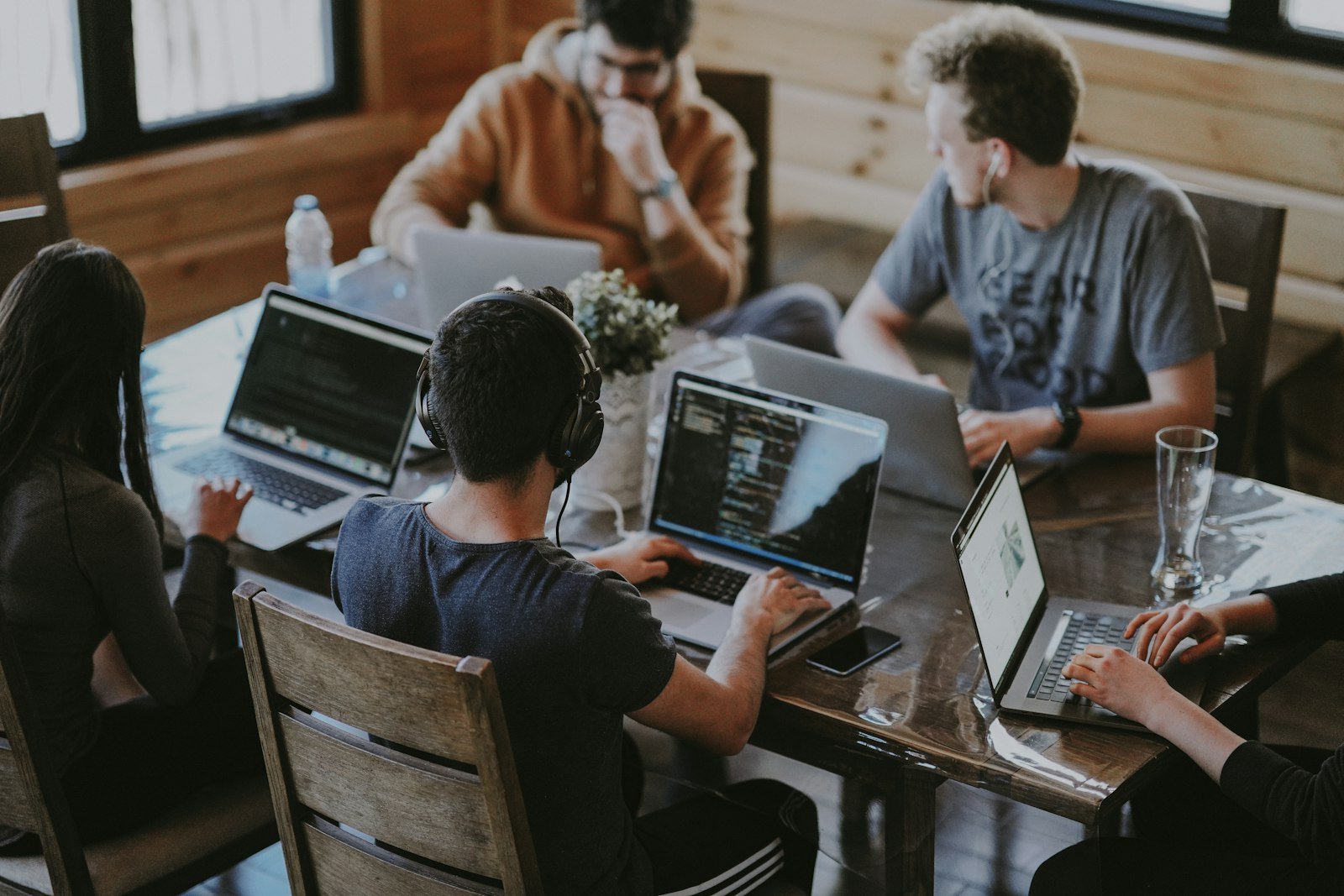 Agentur-Team arbeitet an Laptops am gemeinsamen Tisch